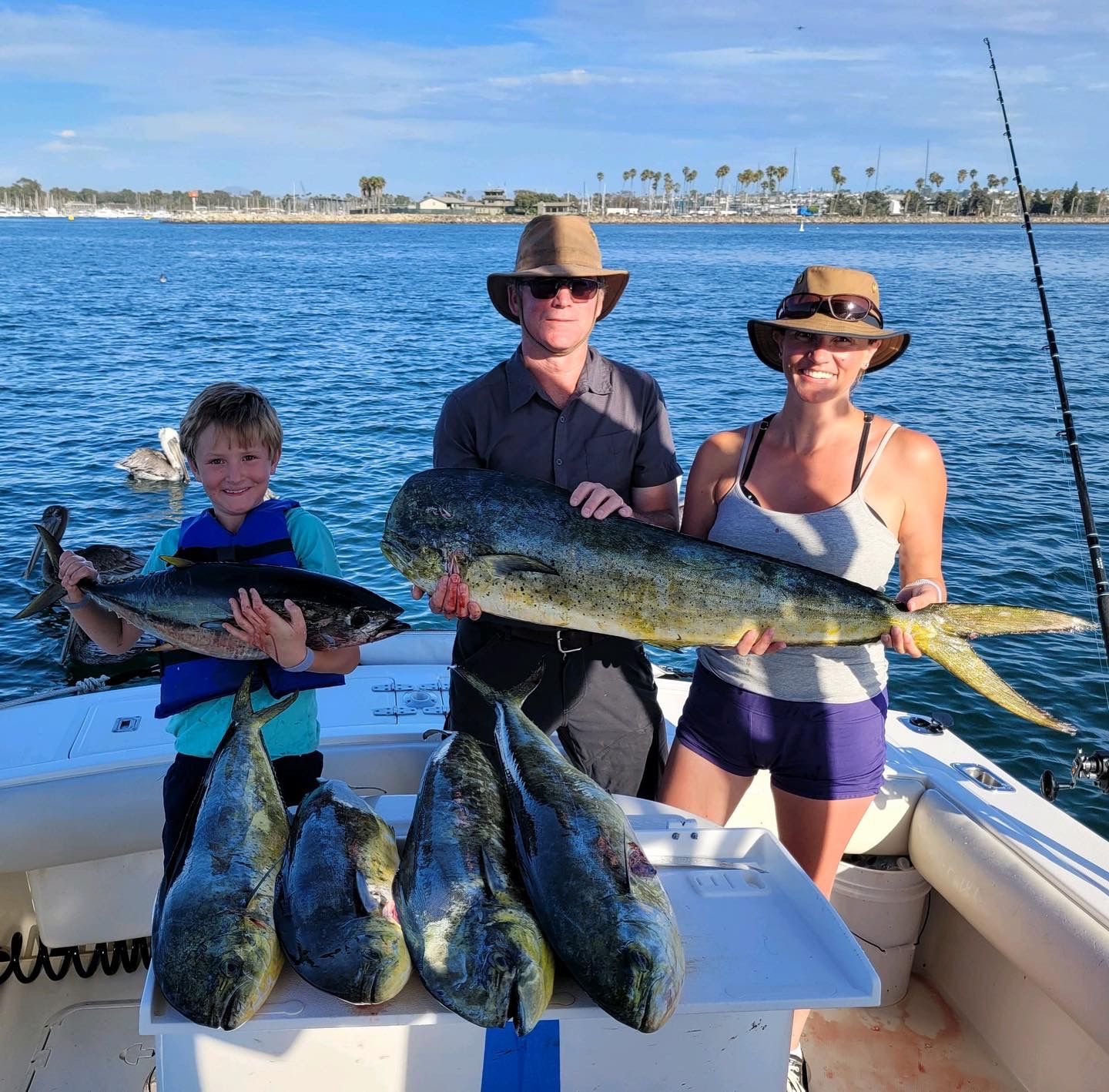 A group of people standing on a boat holding fish
