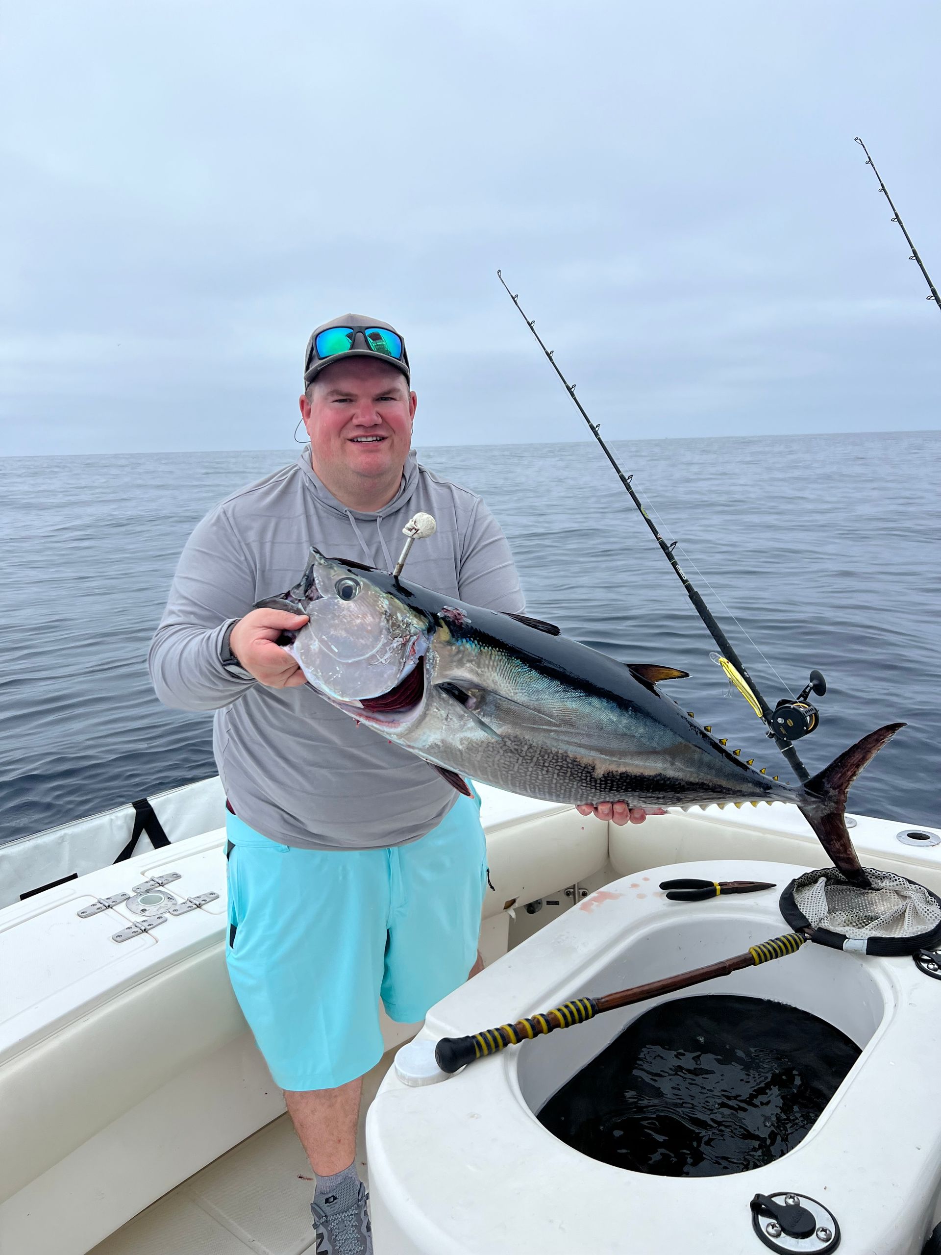 A man is holding a large fish on a boat.