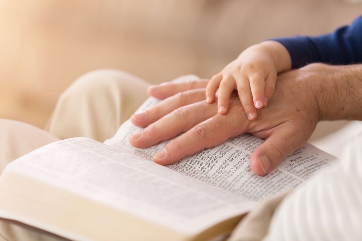 Bambino che accarezza la mano di un adulto