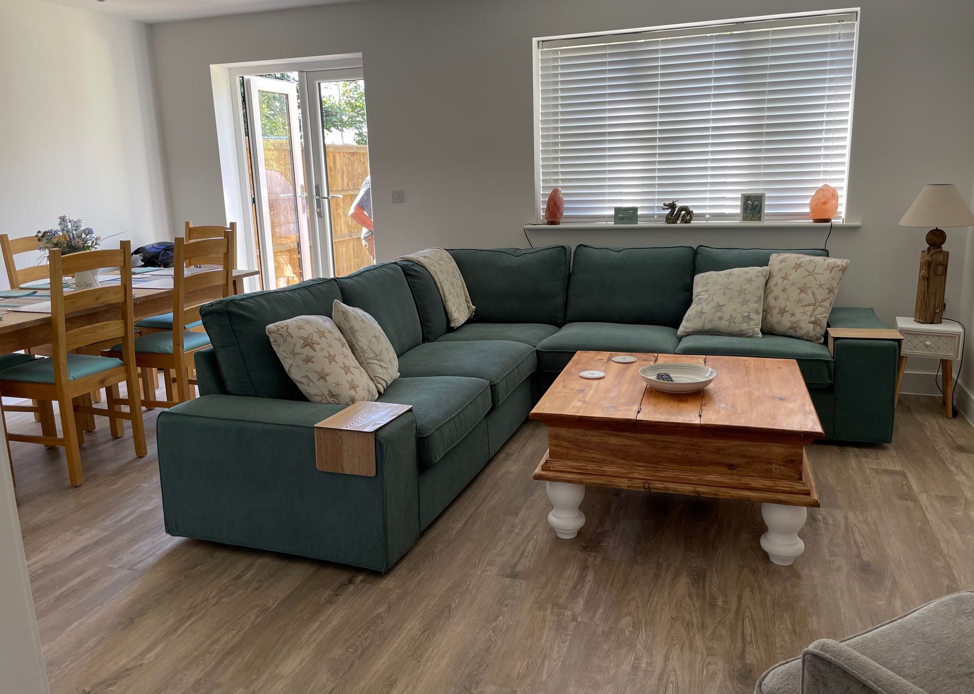A living room with a large sectional couch and a wooden coffee table.
