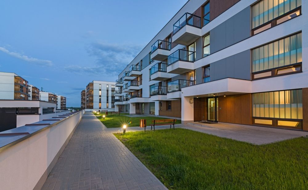 A row of apartment buildings with a walkway between them.