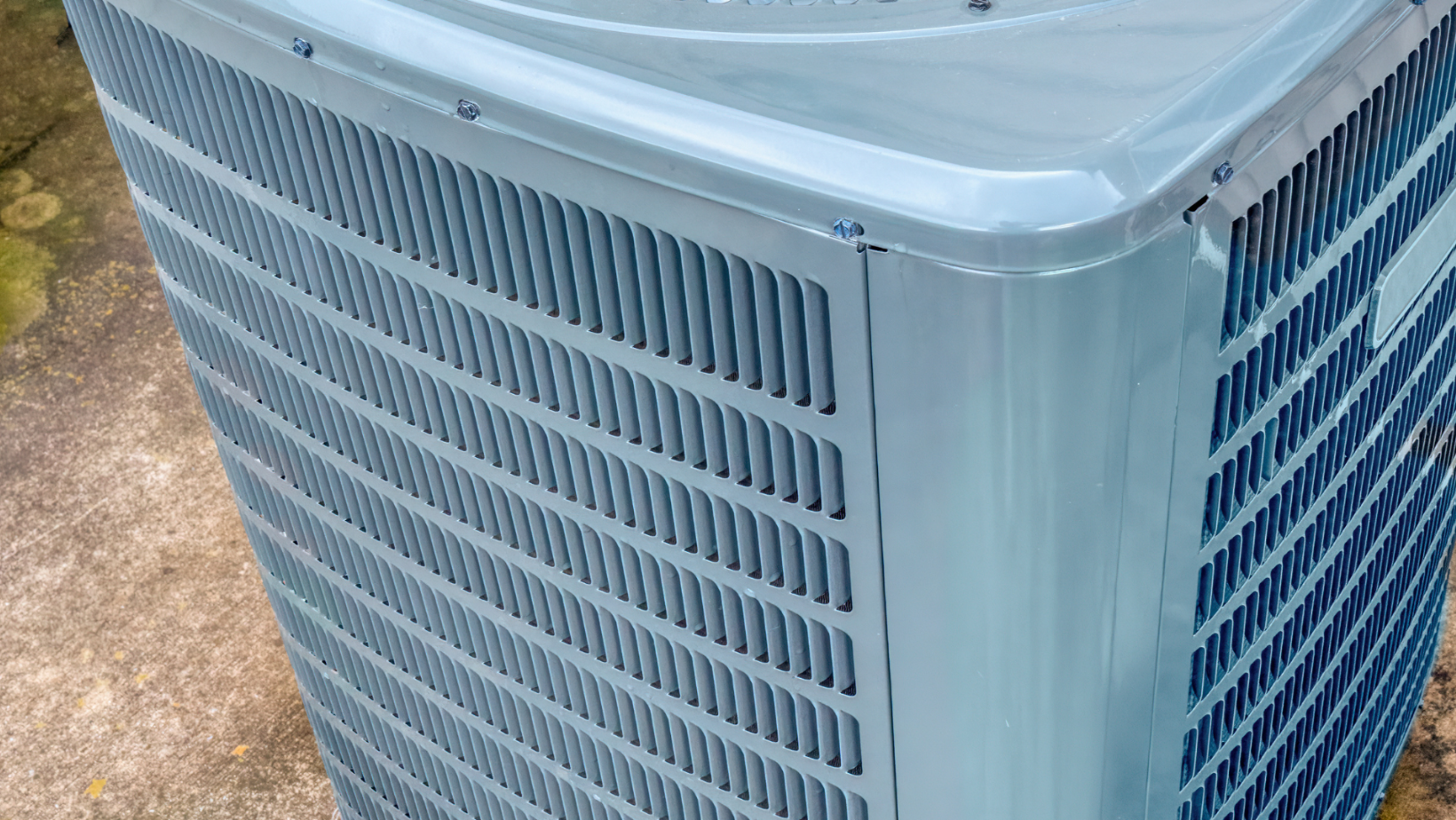 Close-up of a silver outdoor air conditioner unit with vented side panels.