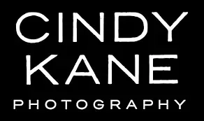 White “CINDY KANE PHOTOGRAPHY” logo on a black background