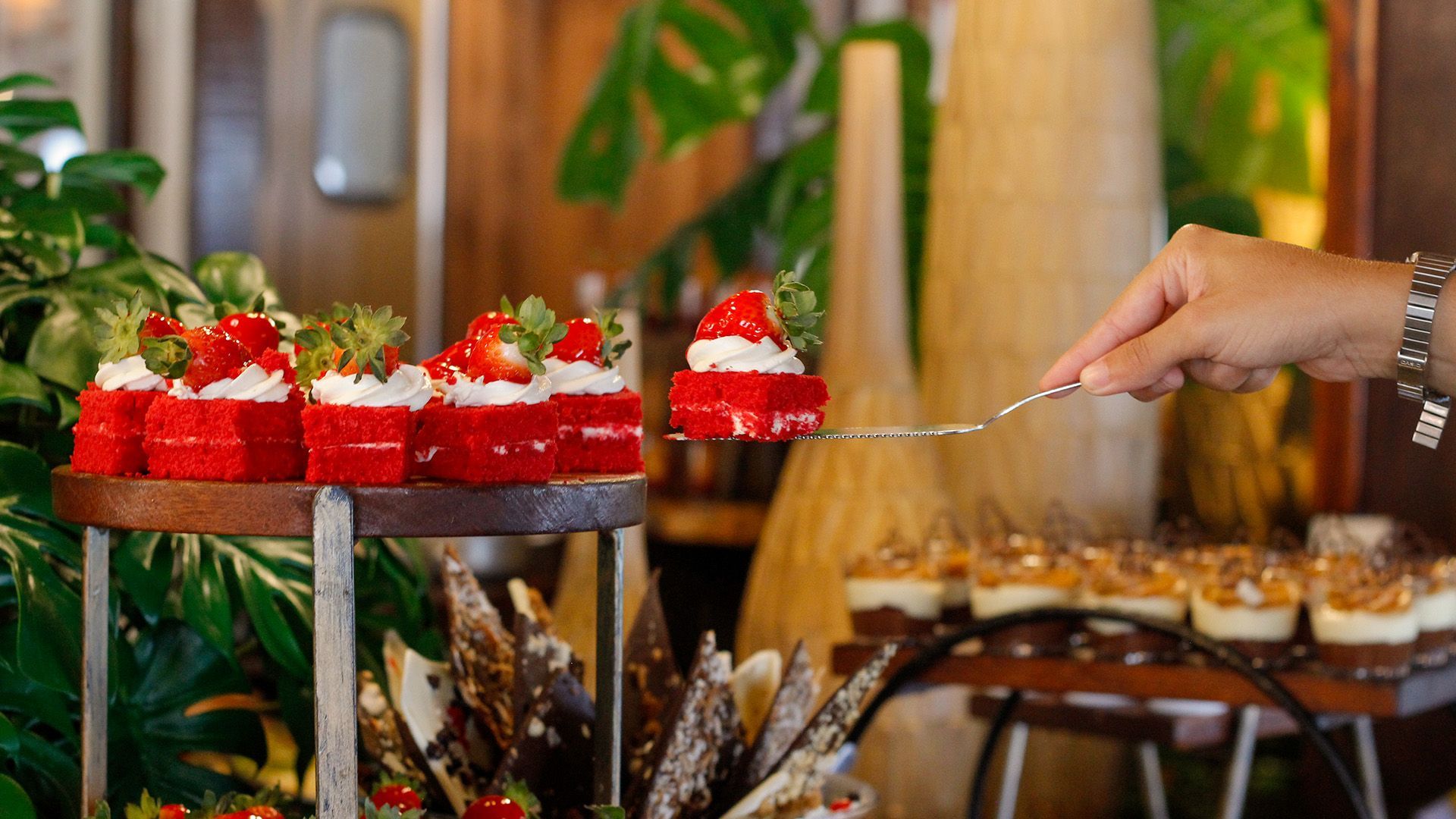 Uma mesa de bufê cheia de sobremesas e flores.
