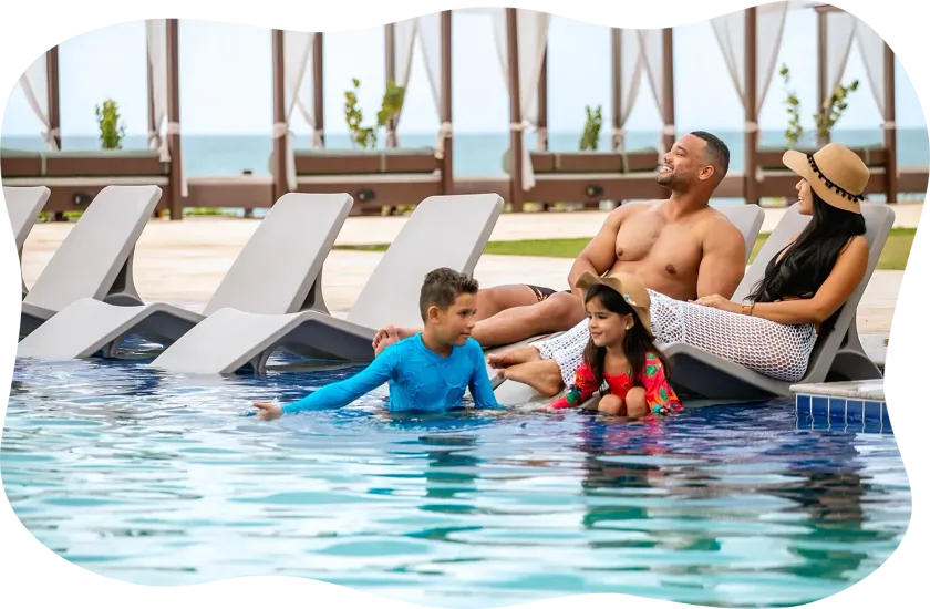 Uma família está sentada em espreguiçadeiras em uma piscina.