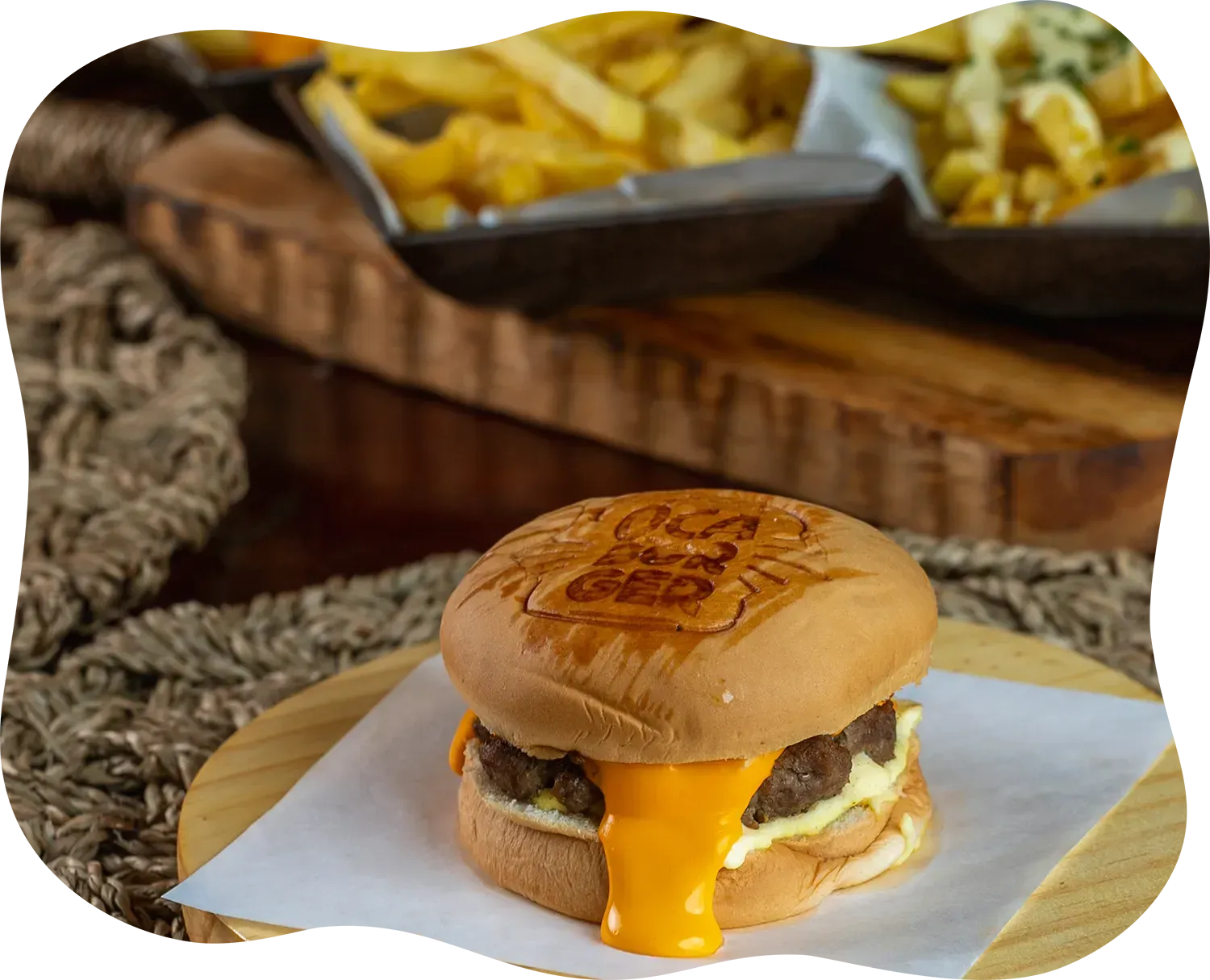 Um hambúrguer e batatas fritas estão sobre uma mesa de madeira.