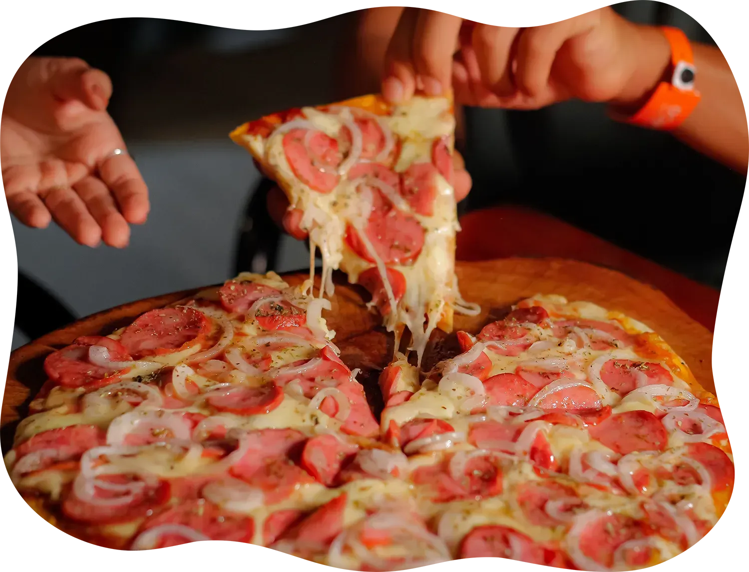 Uma pessoa está pegando uma fatia de pizza