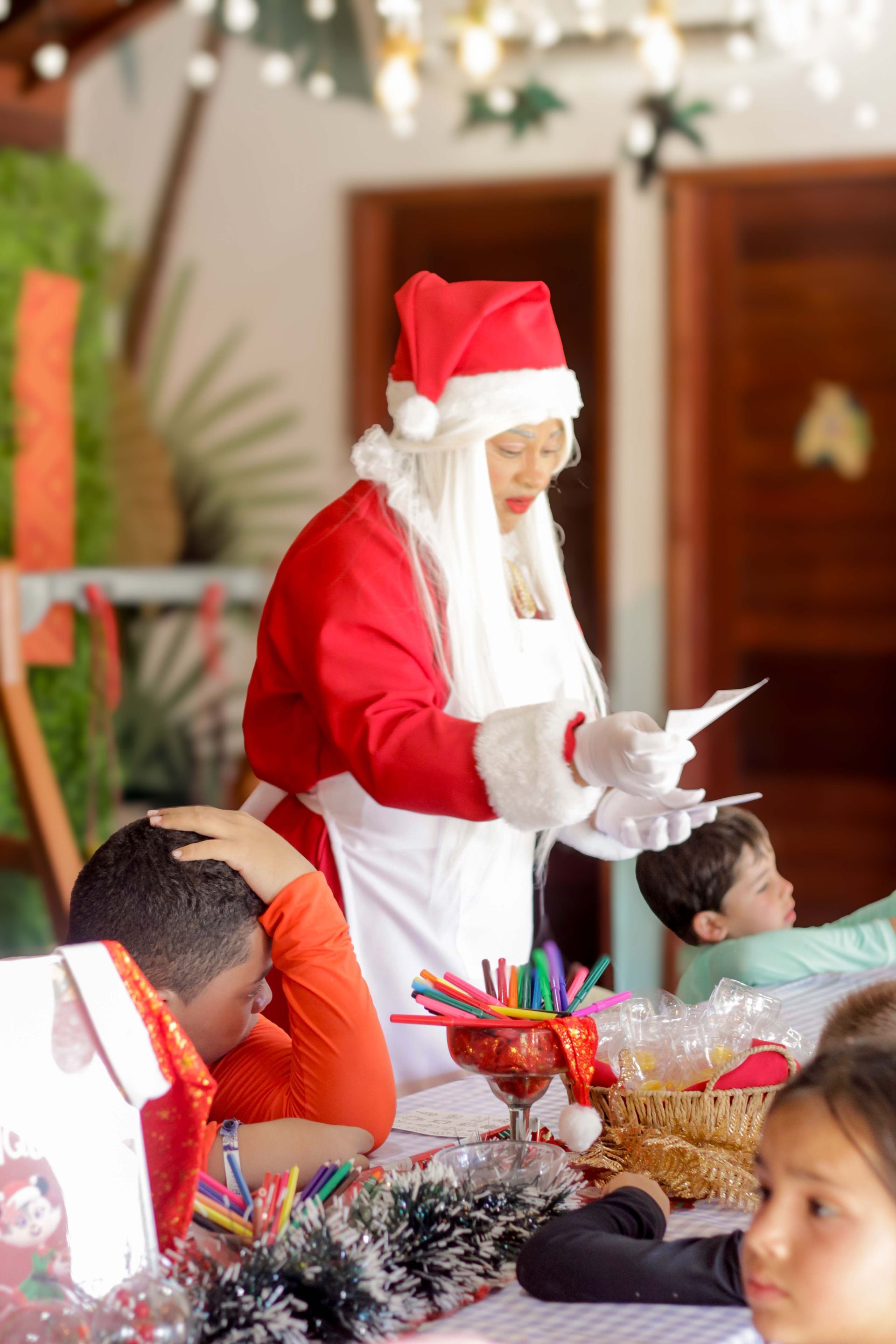 Um grupo de pessoas usando chapéus de Papai Noel estão posando para uma foto em frente a uma piscina.