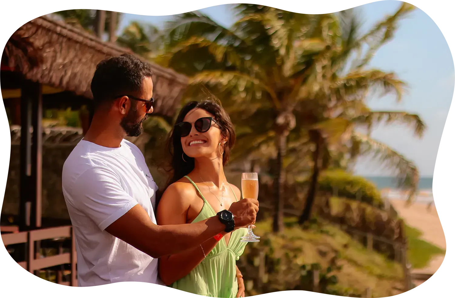 Um homem e uma mulher estão de pé, um ao lado do outro, segurando taças de champanhe.
