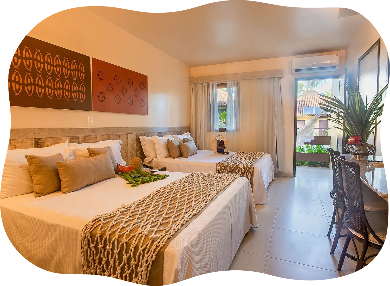 Um quarto de hotel com três camas e uma mesa.