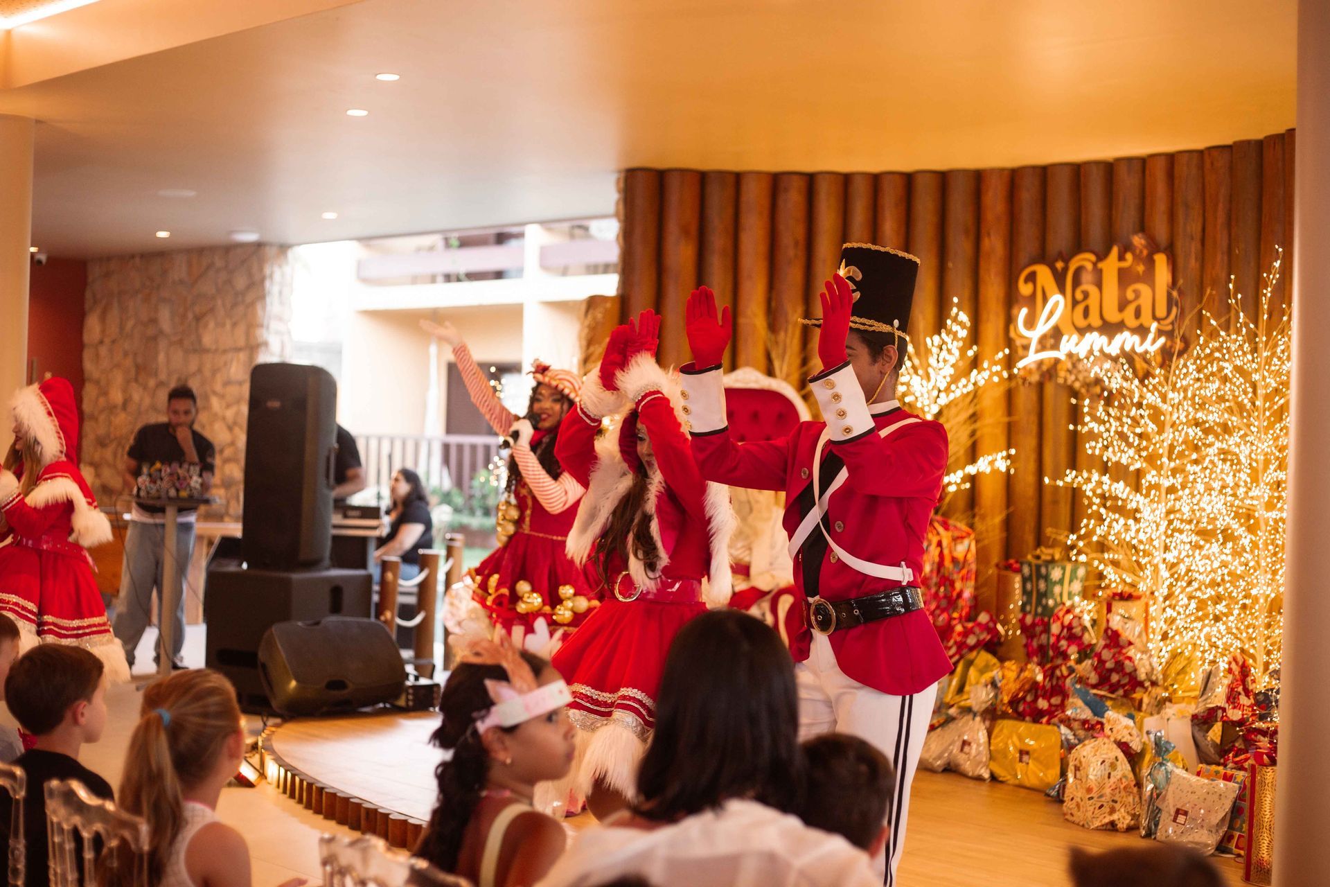 Um grupo de pessoas usando chapéus de Papai Noel estão posando para uma foto em frente a uma piscina.