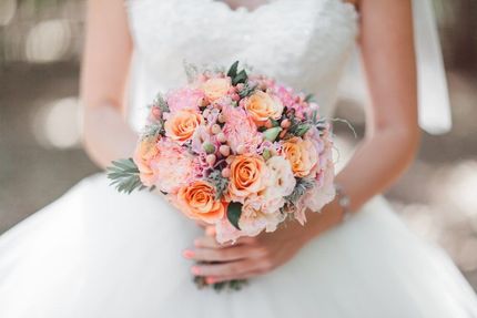 A Bride in a Wedding Dress is Holding a Bouquet of Flowers — The Flower Station Townsville In Kirwan, QLD A Bride in a Wedding Dress is Holding a Bouquet of Flowers — The Flower Station Townsville In Kirwan, QLD