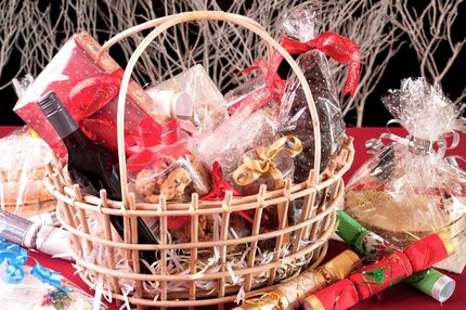 A Wicker Basket Filled With Gifts and Crackers on a Table — The Flower Station Townsville In Kirwan, QLD A Wicker Basket Filled With Gifts and Crackers on a Table — The Flower Station Townsville In Kirwan, QLD