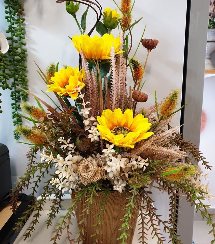 A Podium Decorated With White Flowers and Candles on a Wooden Floor — The Flower Station Townsville In Kirwan, QLD