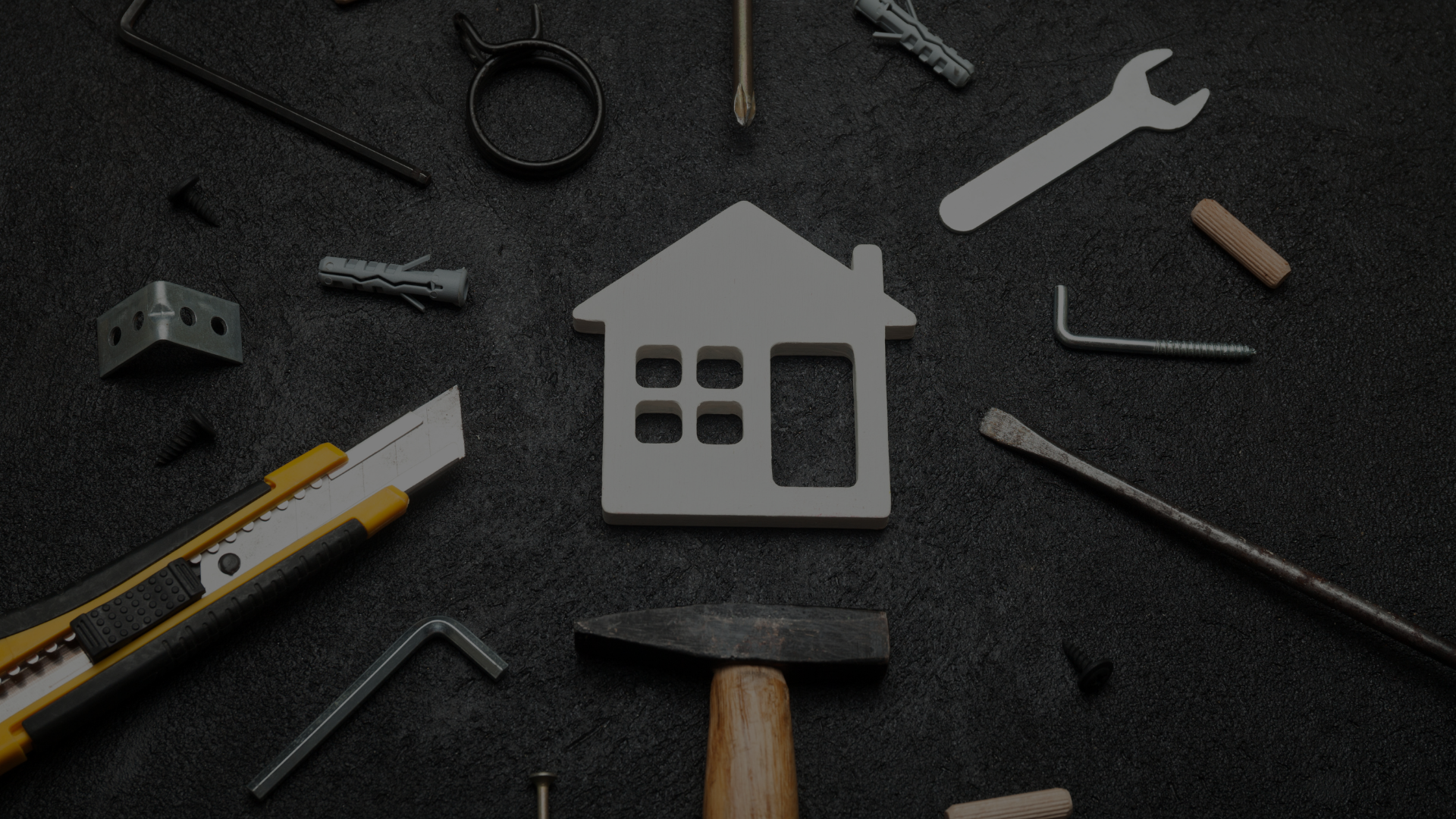 There is a model of a house surrounded by tools.