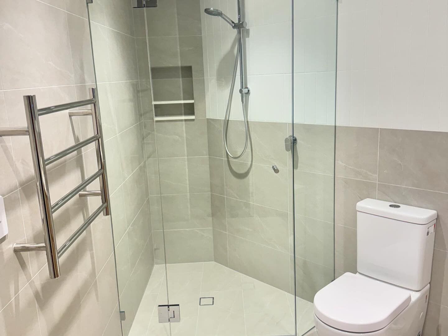 Accessible bathroom with walk-in shower, toilet, grab bar, and towel rail. — New Gen Plumbing and Gas in Banora Point, NSW