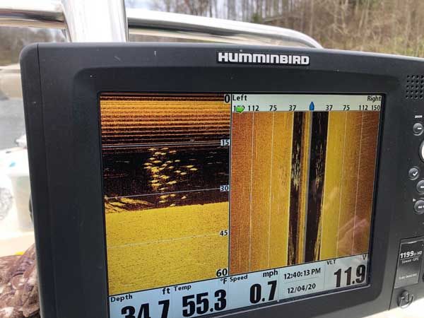 Humminbird fish finder display showing sonar scans and water depth readings on a boat