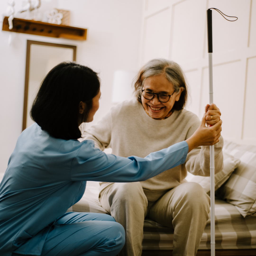 A nurse is helping an elderly woman with a cane