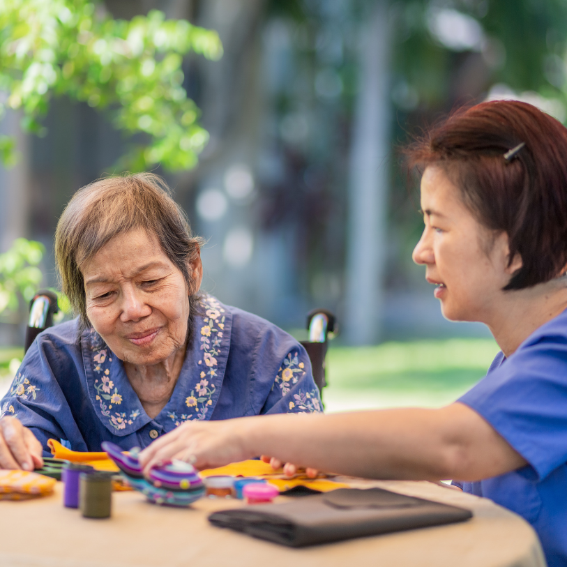 Two women are sitting at a table playing with toys.