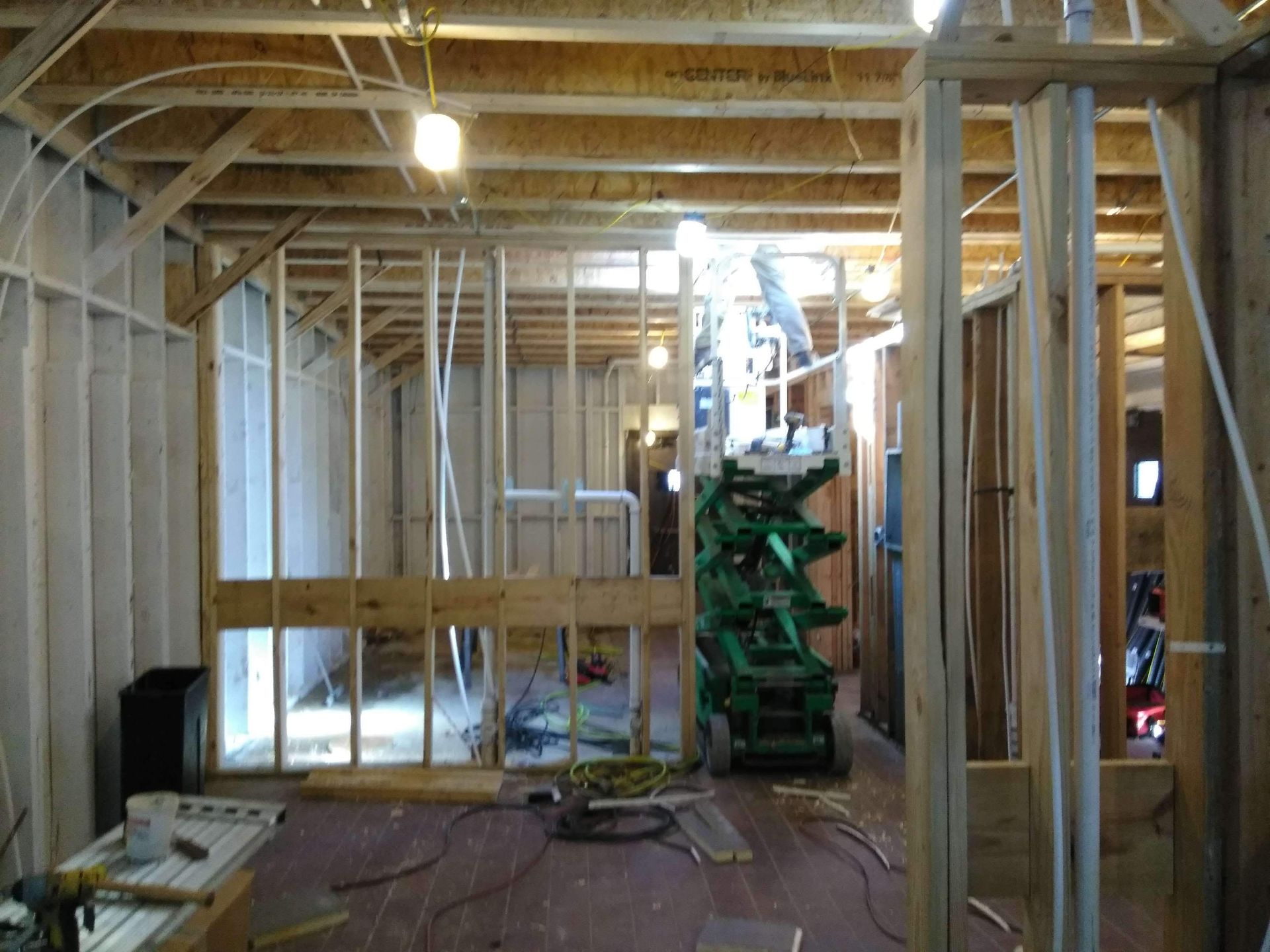 A room under construction with a green lift in the background