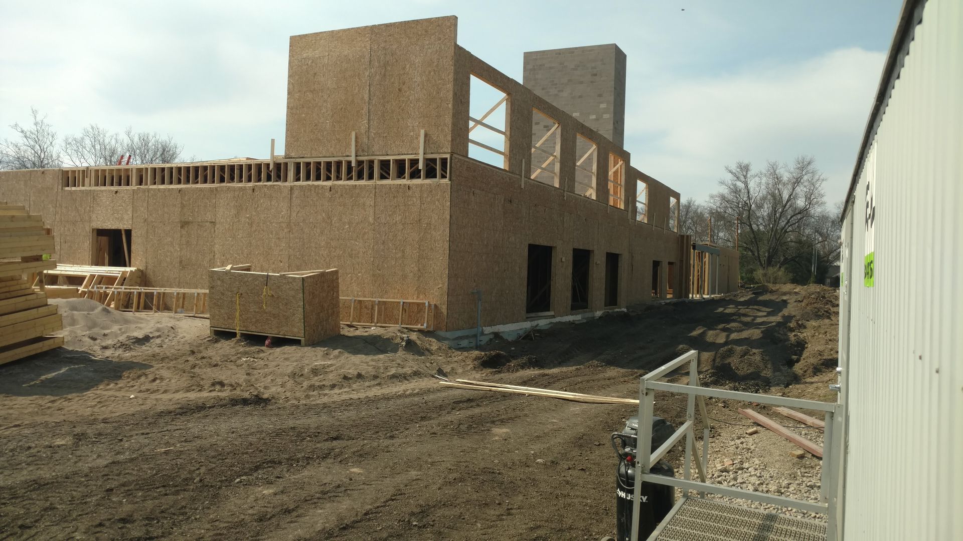 A large building is being built in a dirt field