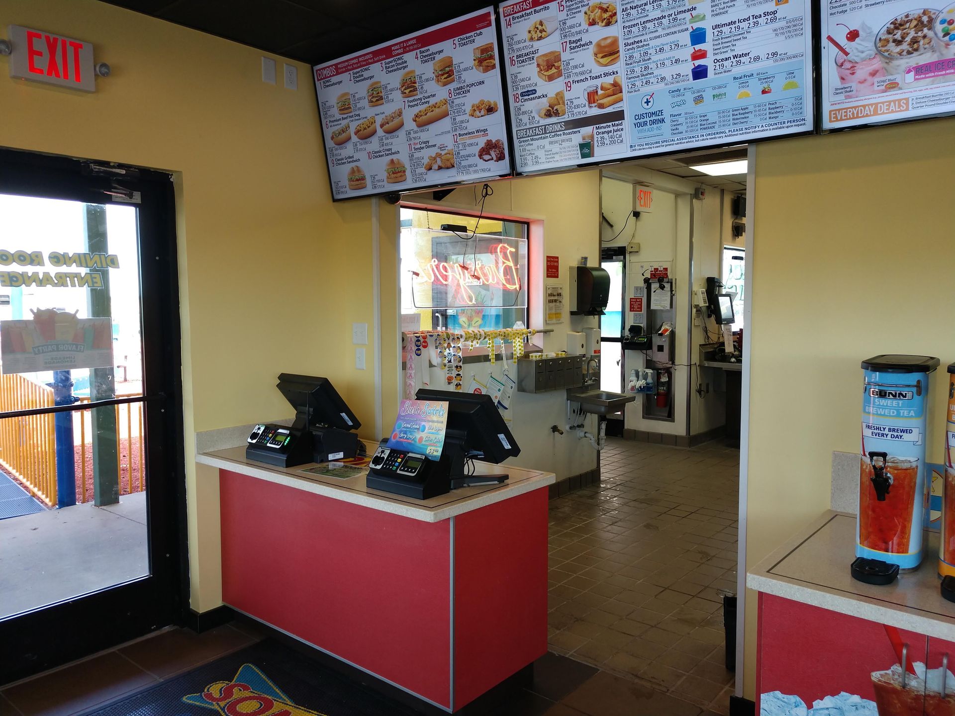 A fast food restaurant with an exit sign above the counter