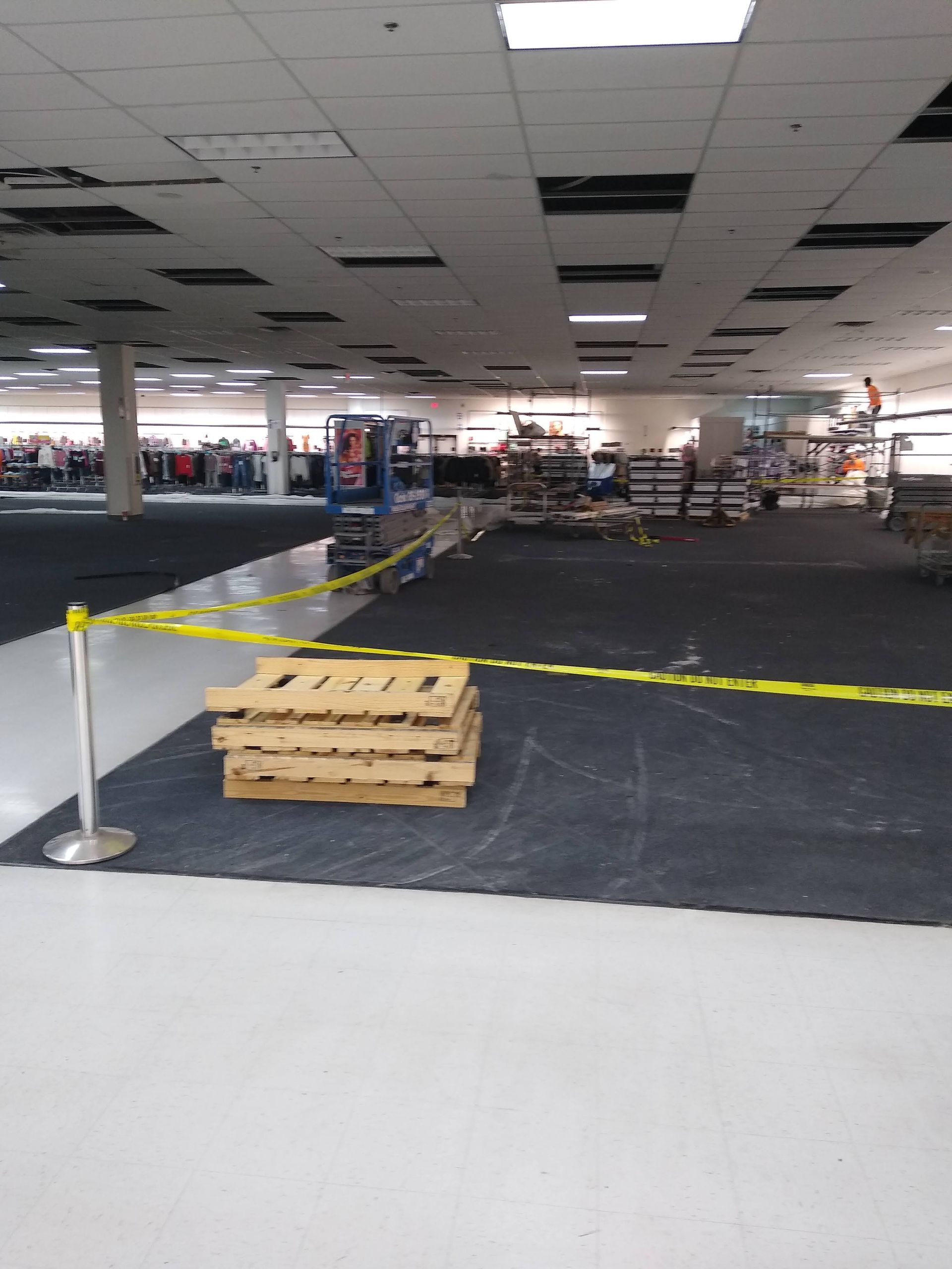 A stack of wooden pallets is sitting in the middle of an empty store.
