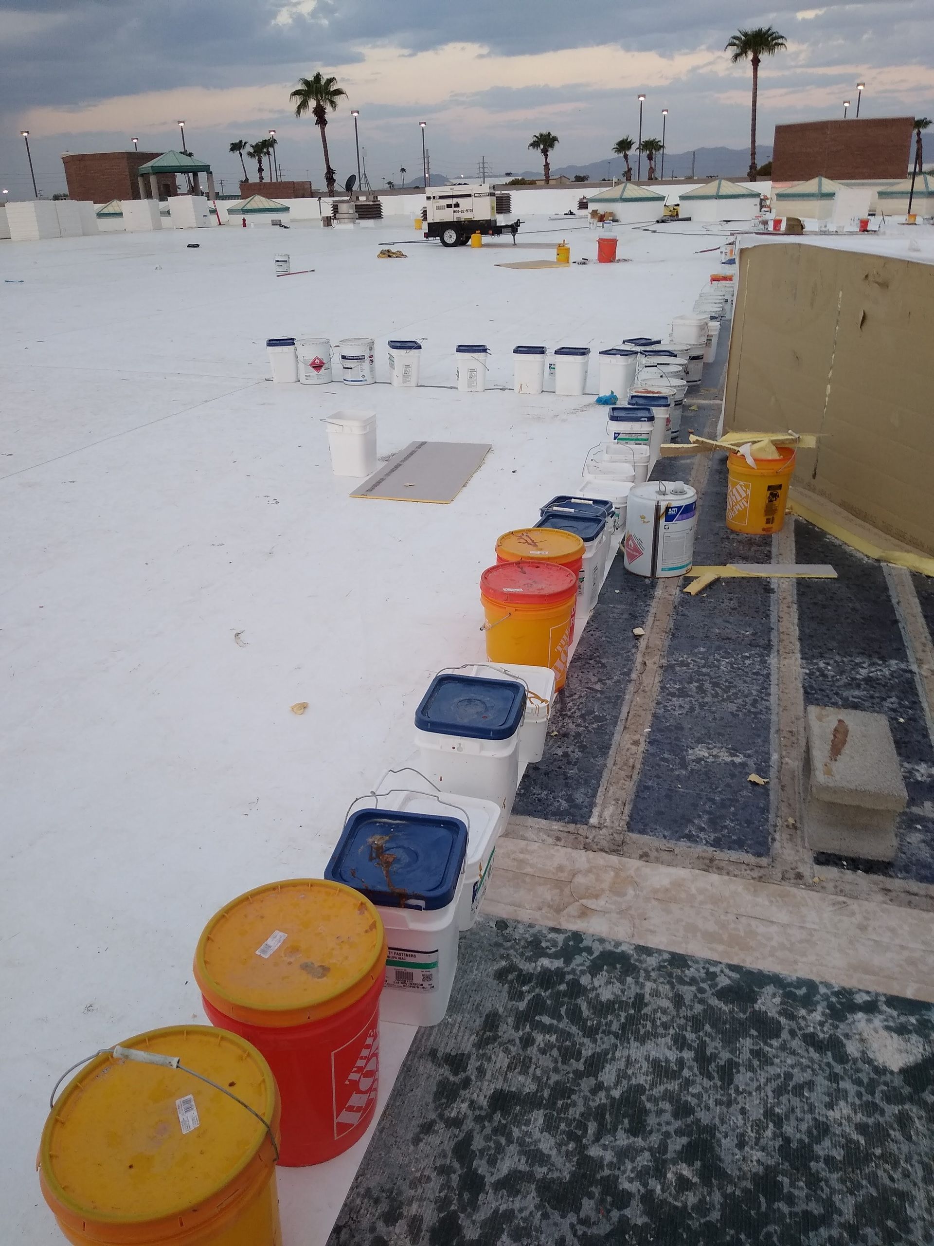 Buckets of paint are lined up on a white surface