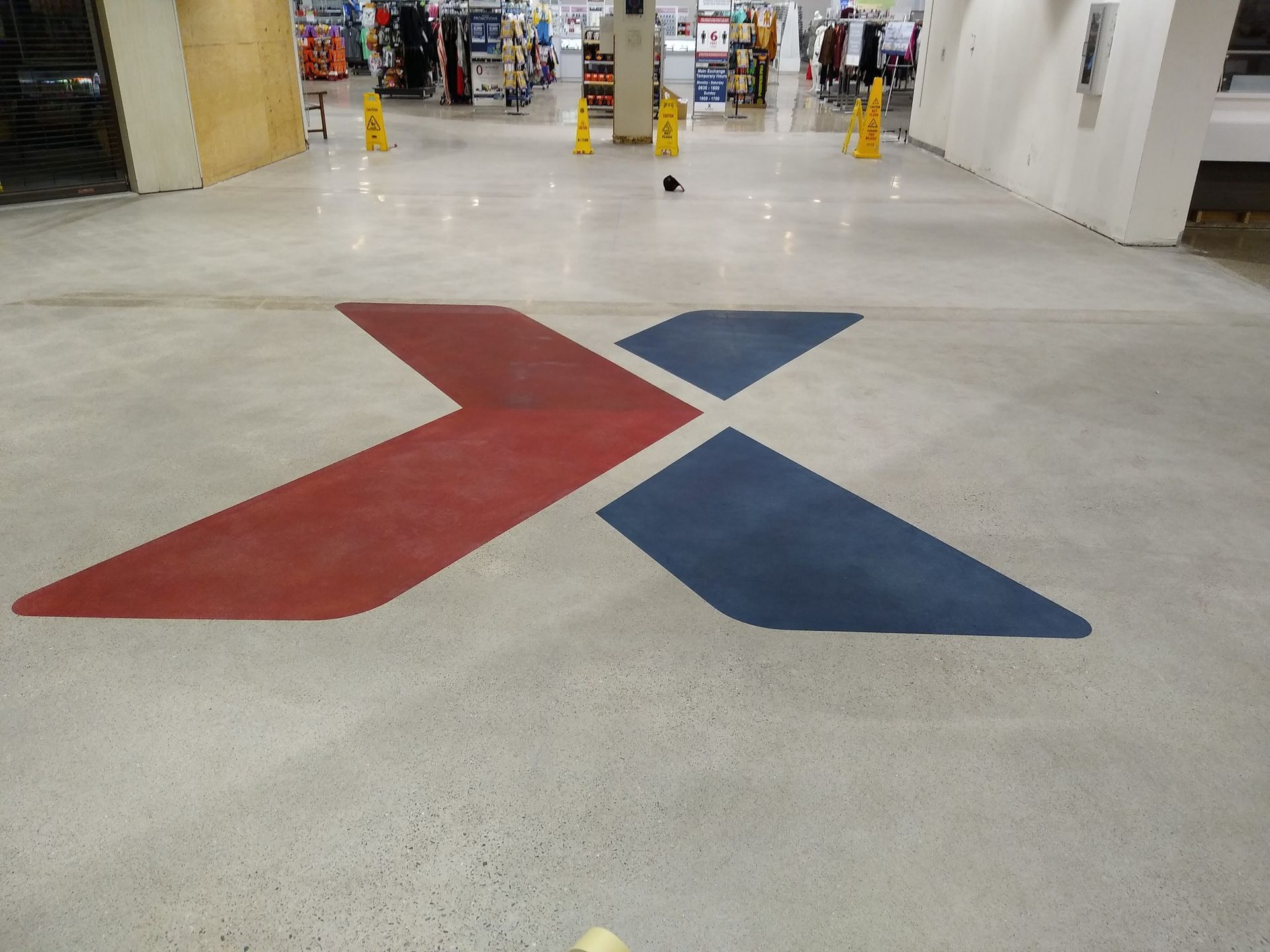 A red and blue x is painted on the floor of a store