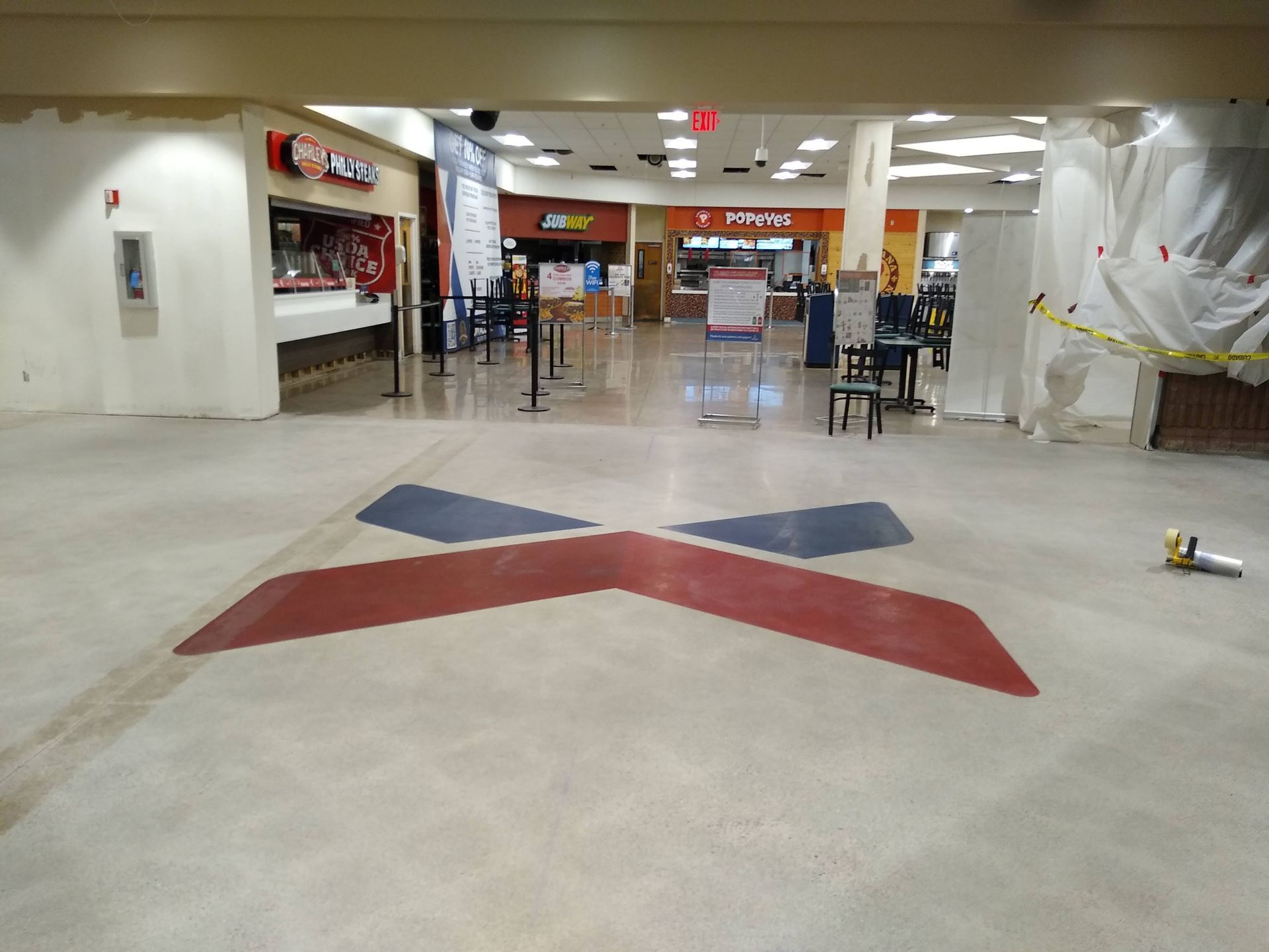 A large room with a red white and blue x on the floor