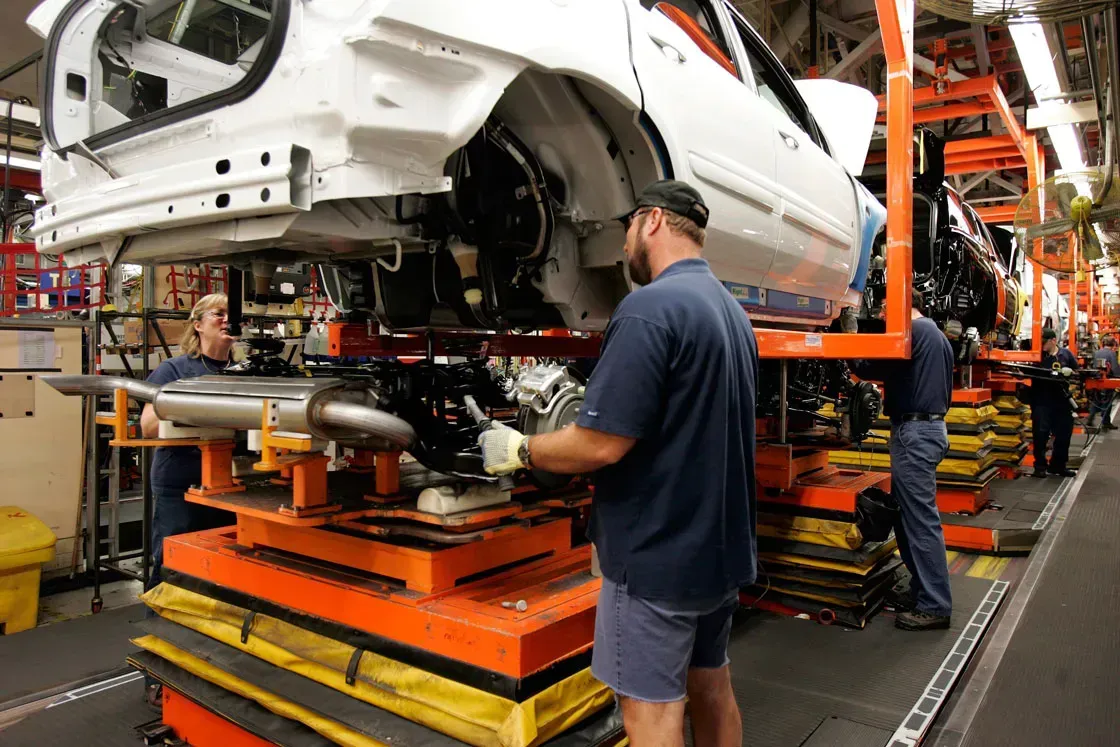 Automotive manufacturing workers wearing safety gloves