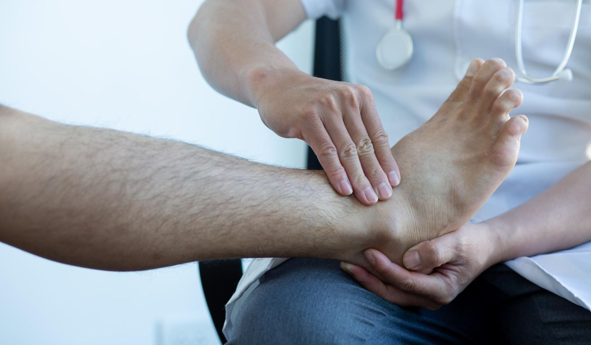 A Doctor Is Examining A Patient's Ankle — Trinity Family Chiropractic In Cairns City, QLD 