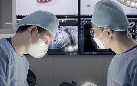 Dentists reviewing a CT scan before implant surgery