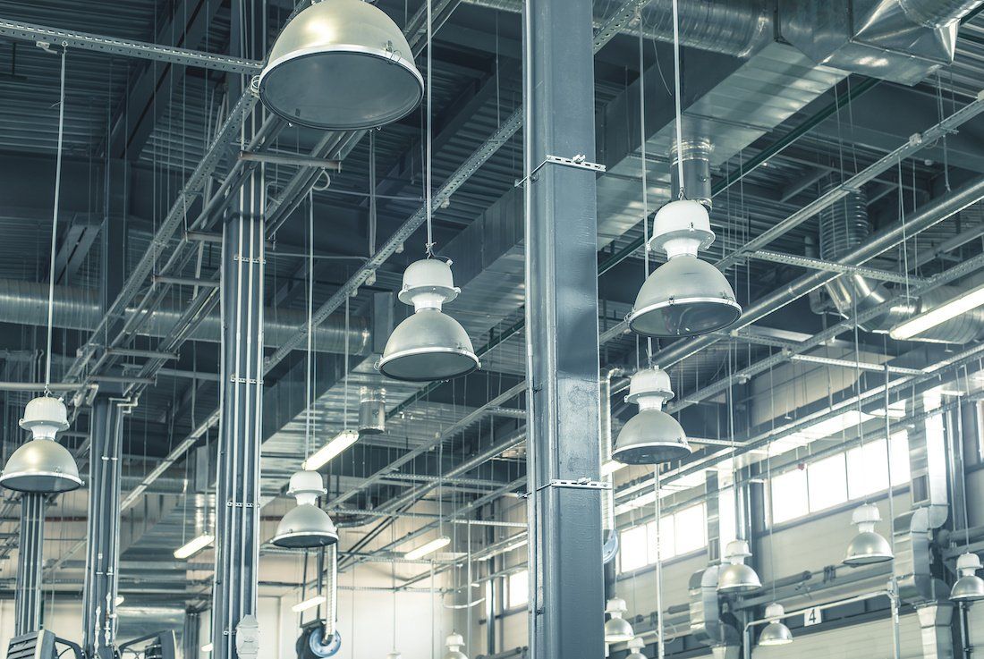 There are a lot of lights hanging from the ceiling of a building.