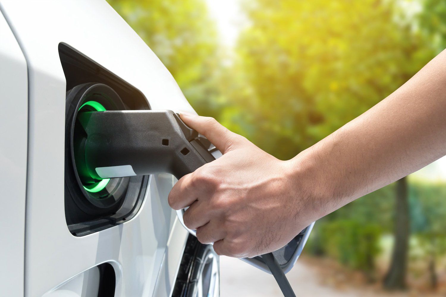 A person is charging an electric car with a charger.