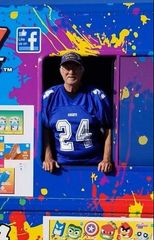 Man in a blue #24 jersey stands in a colorful blue and purple frame with paint splatters