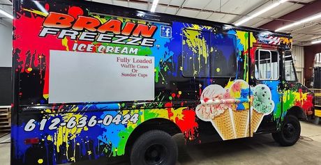 Colorful Brain Freeze truck parked indoors with a whiteboard side panel and ice cream graphics