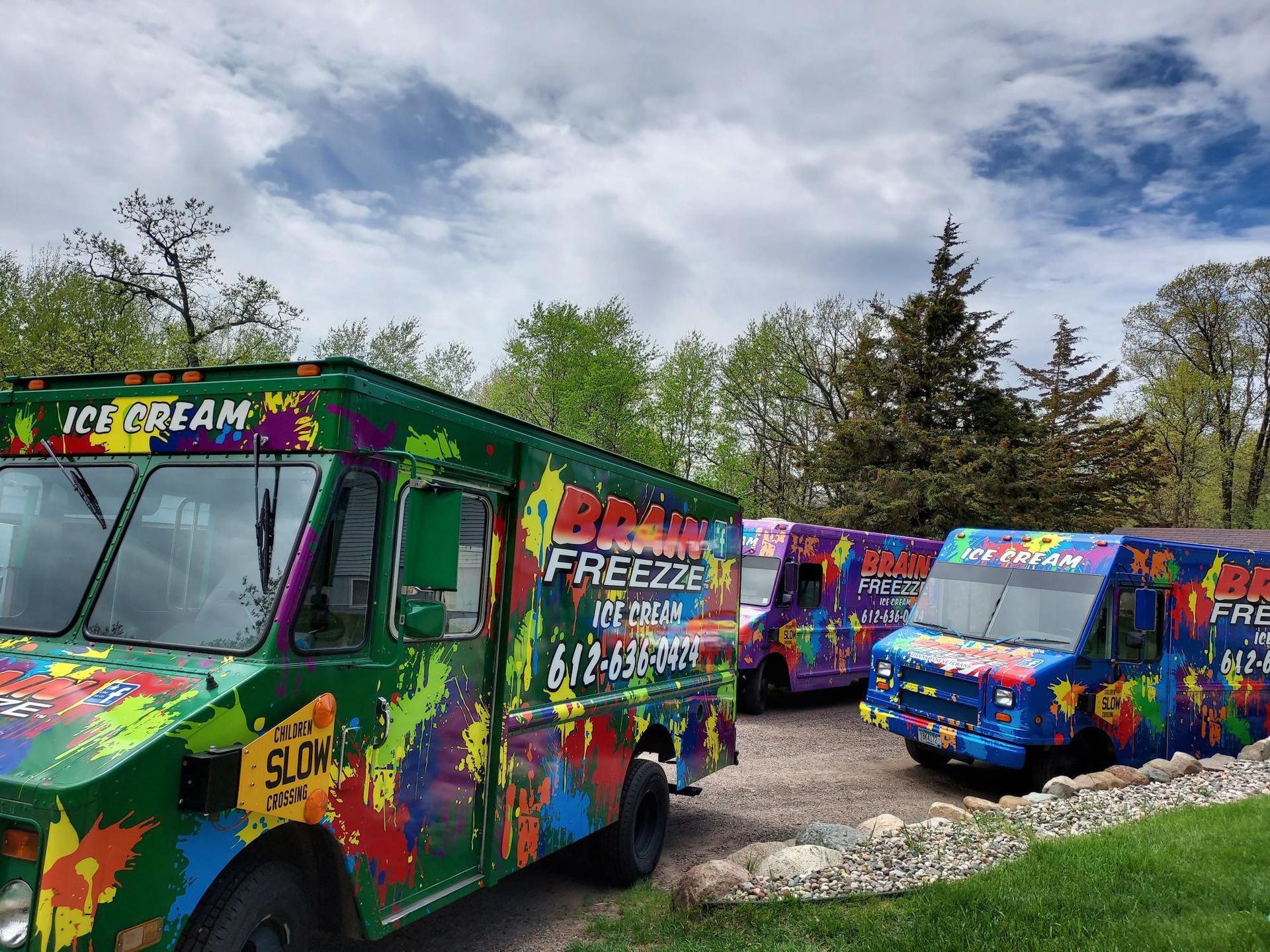Colorful ice cream trucks parked outdoors on a sunny day