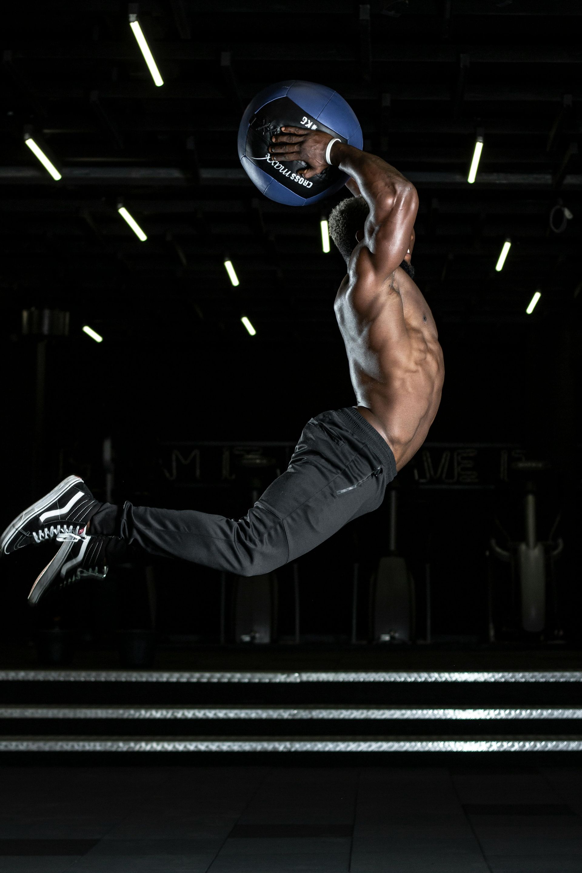 A man is jumping in the air while holding a medicine ball.