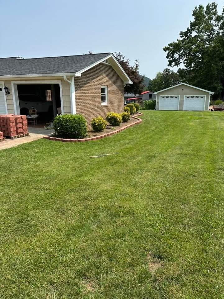 Suburban house with a large green lawn and detached garage on a sunny day