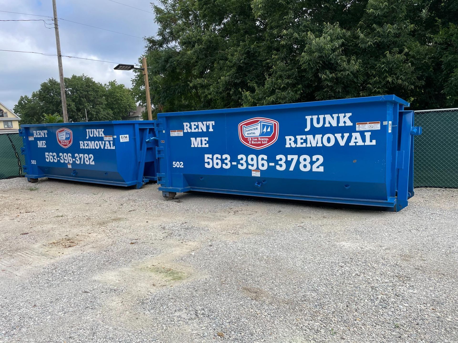 Two blue dumpsters labeled 