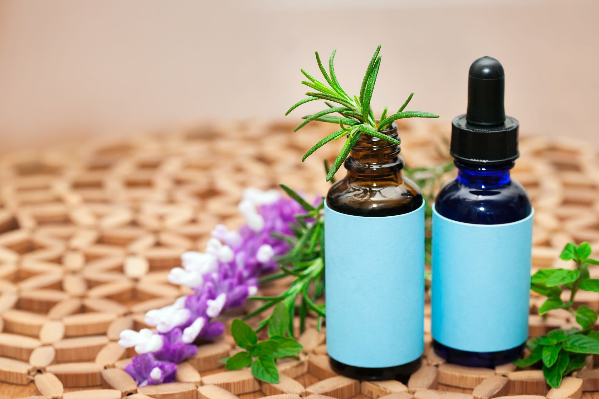 Two bottles of essential oils are sitting on a wooden table. Two bottles of essential oils are sitting on a wooden table.