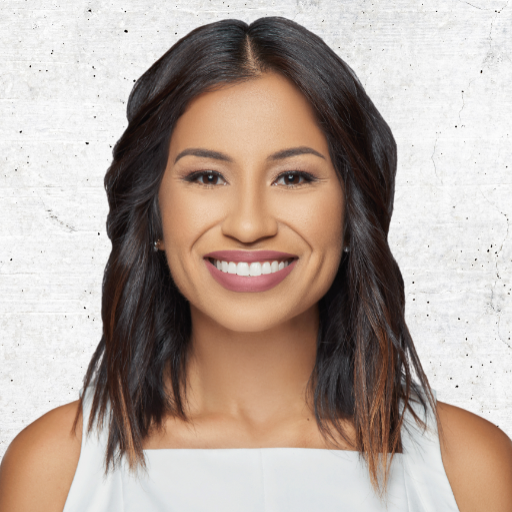 Smiling woman with dark shoulder-length hair in a white top against a light textured background