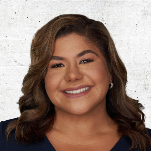 Smiling woman with wavy brown hair against a light gray background
