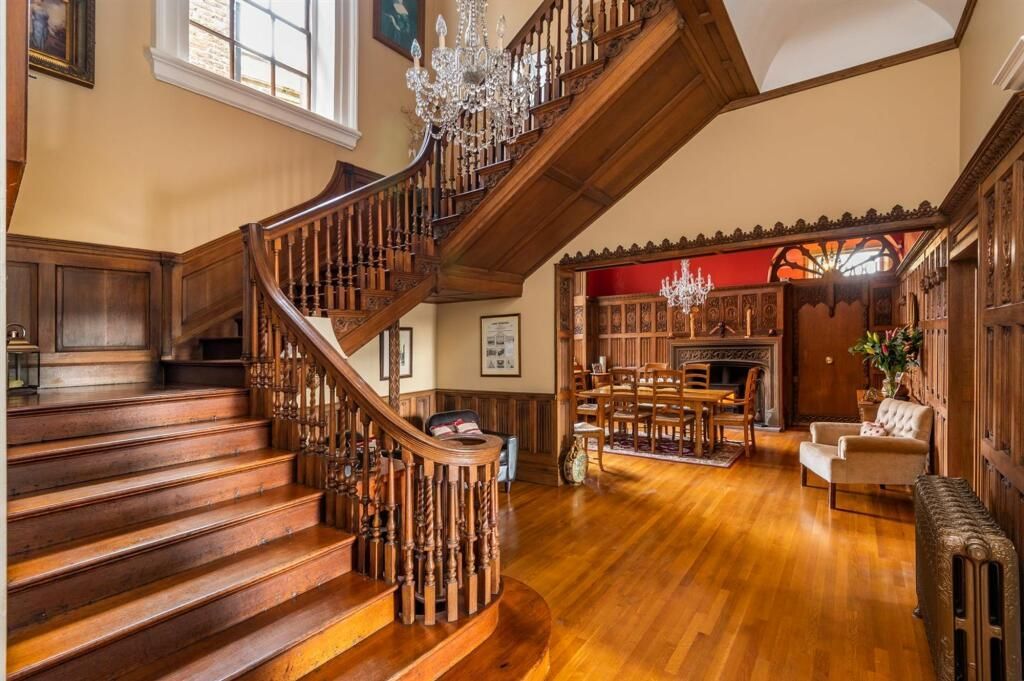 Grand period staircase – rich polished timber treads and balustrade preserved with meticulous care, opening to elegant spaces
