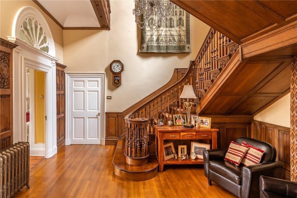 Grand staircase – warm wood panelling and carved balusters brought back to life with devoted attention to period character