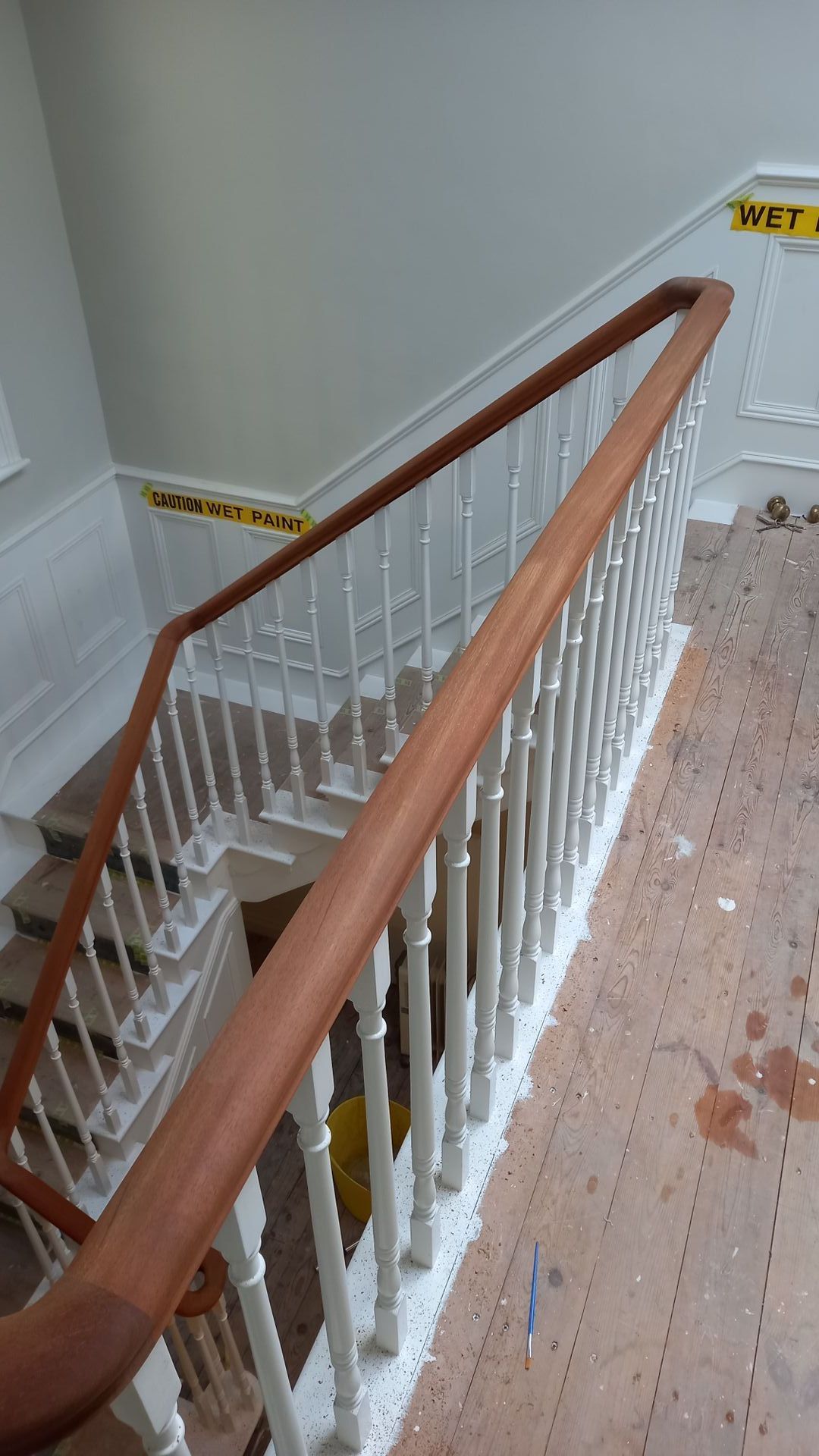Thoughtful mid-preparation of heritage staircase – crisp white spindles emerging, handrail ready for finish