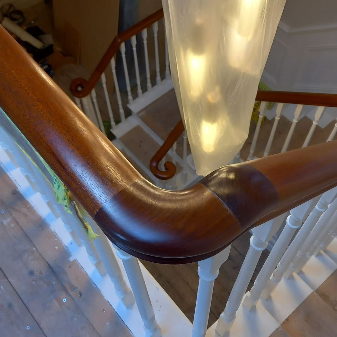Carefully restored period handrail – rich rosewood stain applied with precision, original curves