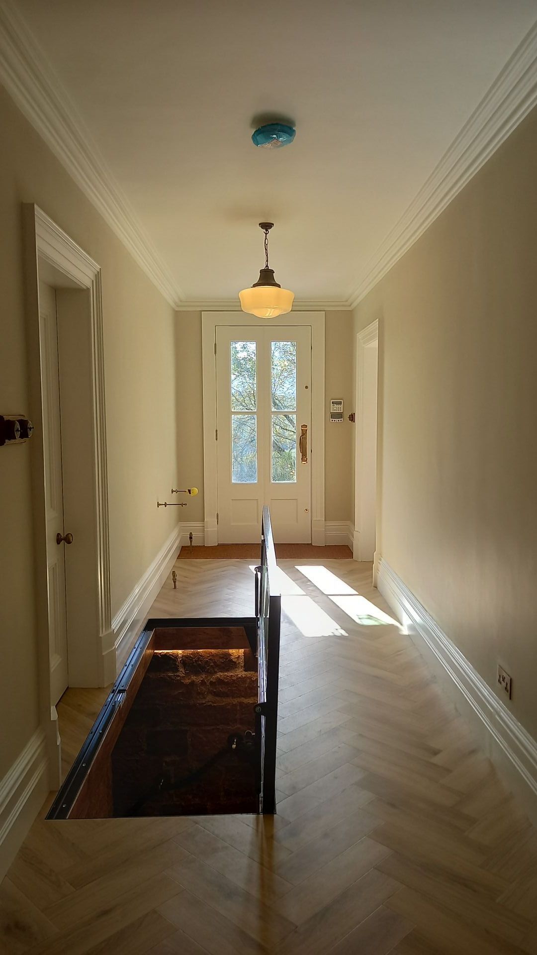 Gracefully restored period hallway – soft neutral tones and herringbone flooring preserved with precision and care