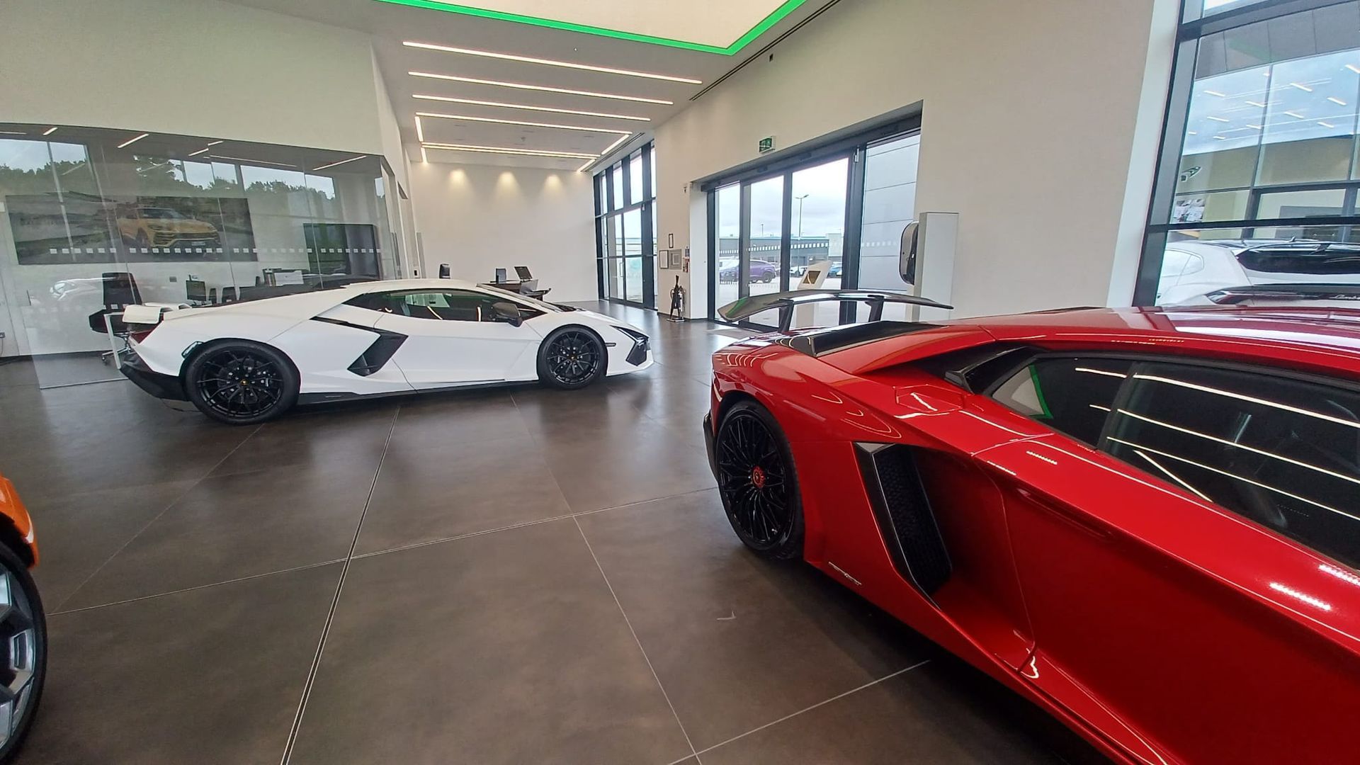 Premium commercial painting – sleek neutral walls and crisp detailing applied to complement dramatic supercar displays